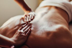 Close-up of masseur's hands and a client's back